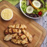 top view sliced  grilled chicken breast with sauce and vegetable salad